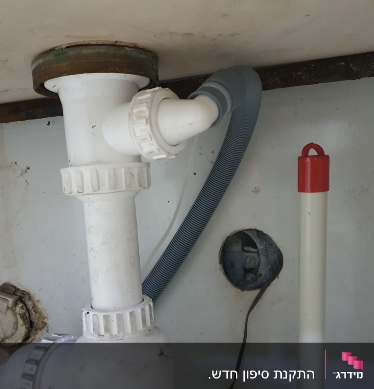 צינור פלסטיק לבן עם מחברים מתחת לכיור